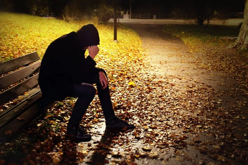 depressed man on a bench with emotional injuries