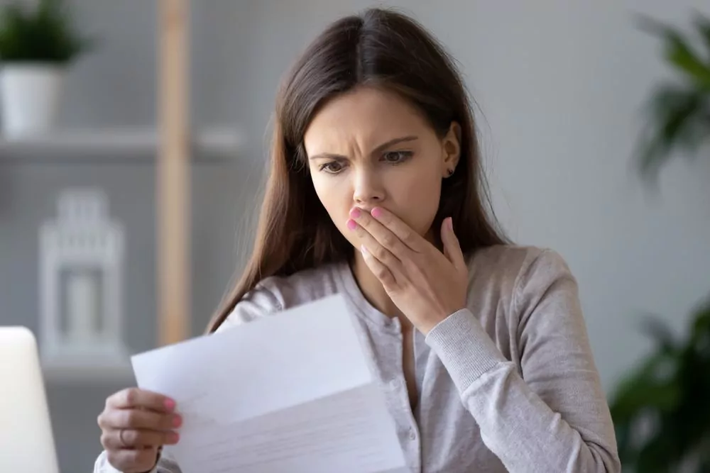 woman looking at car insurance bill