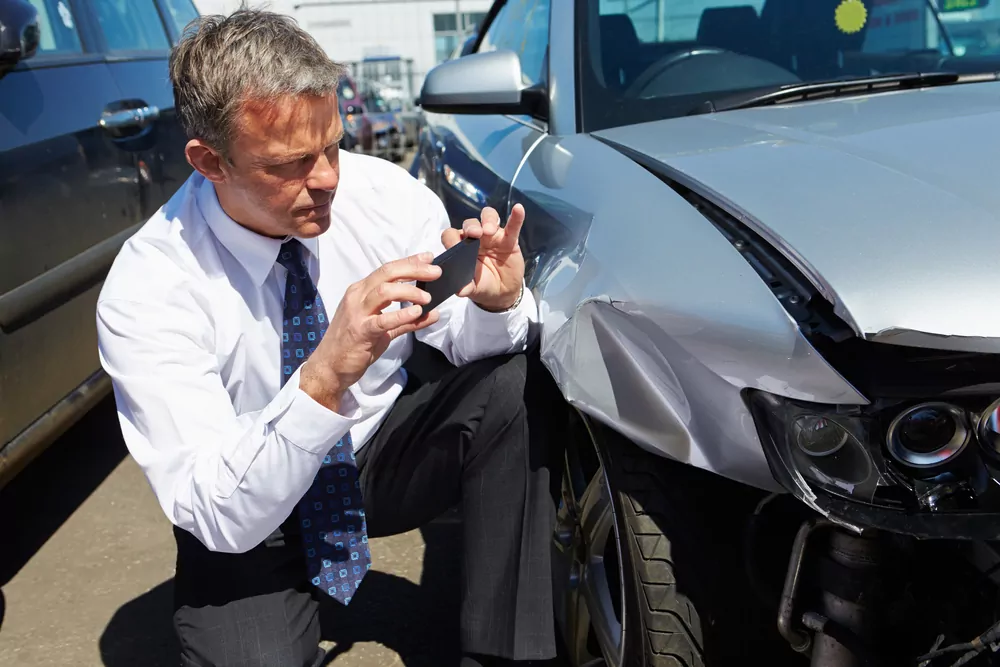 insurance adjuster taking pictures of car accident